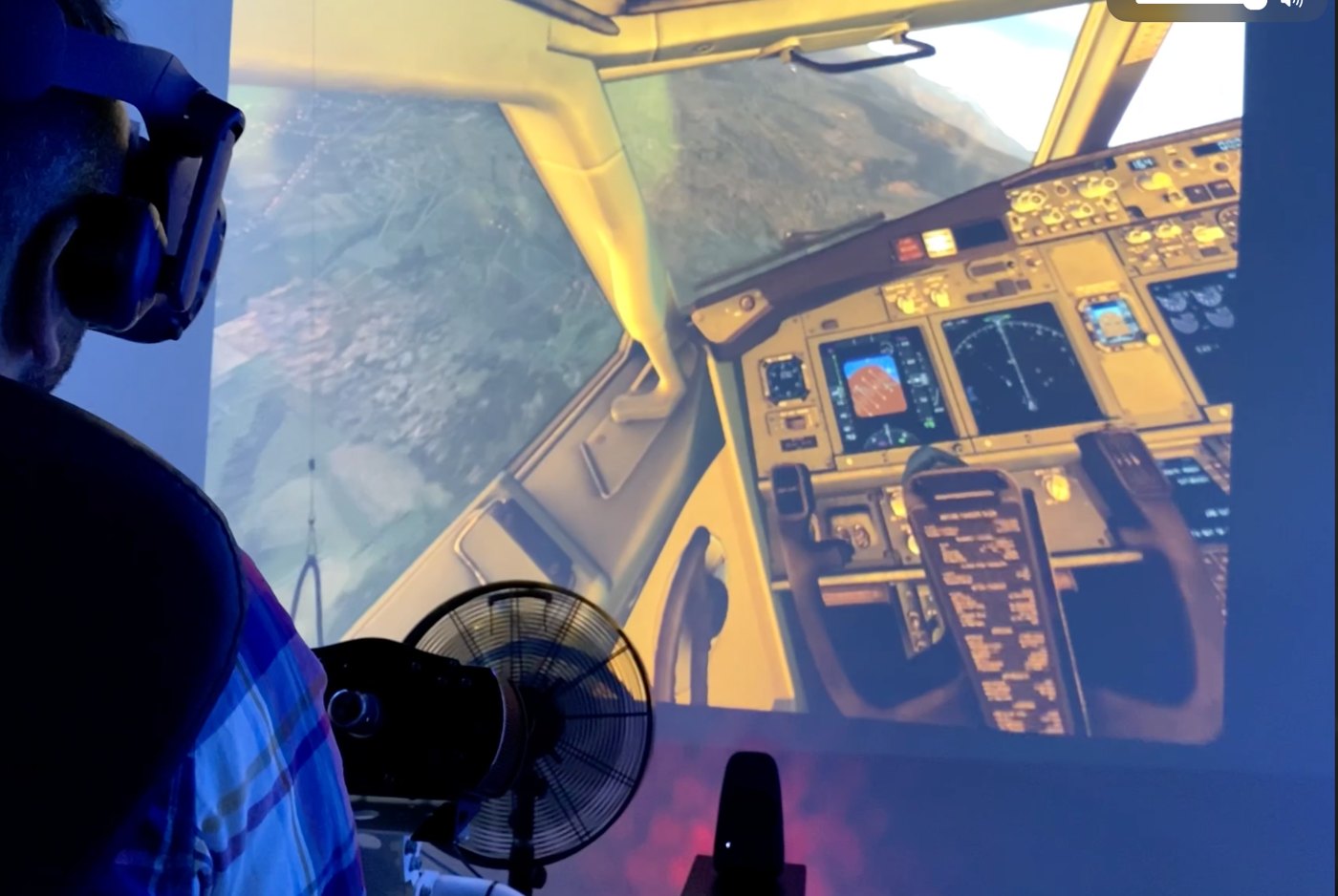 VR-Flugsimulator im Cosmic VR Studio Wildau — Spieler mit Headset vor der Cockpit-Projektion